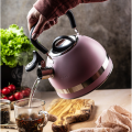 Czajnik stalowy 1,8 l różowy z ergonomicznym uchwytem – widok w trakcie nalewania wody do filiżanki.